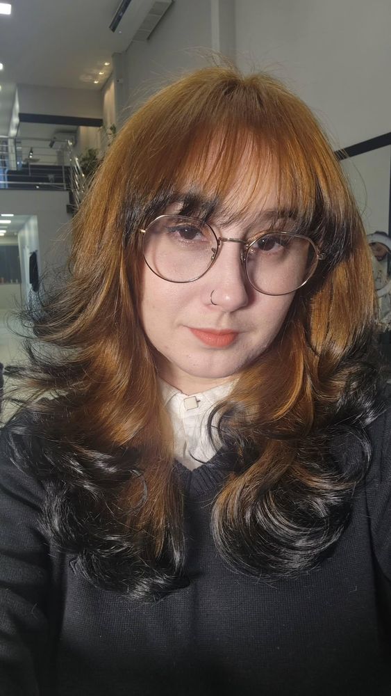selfie minha de óculos, com o cabelo pintado de ruivo e escovado. As pontas estão pretas. Visto um blusão preto com uma camisa branca por baixo