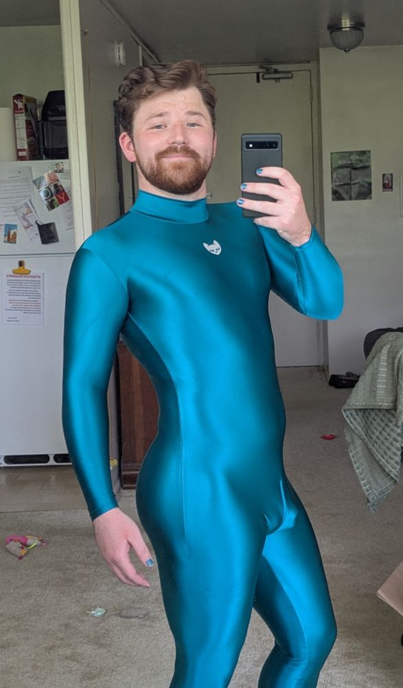 Myself posing in the mirror in front of the window to take a pic with my team suit