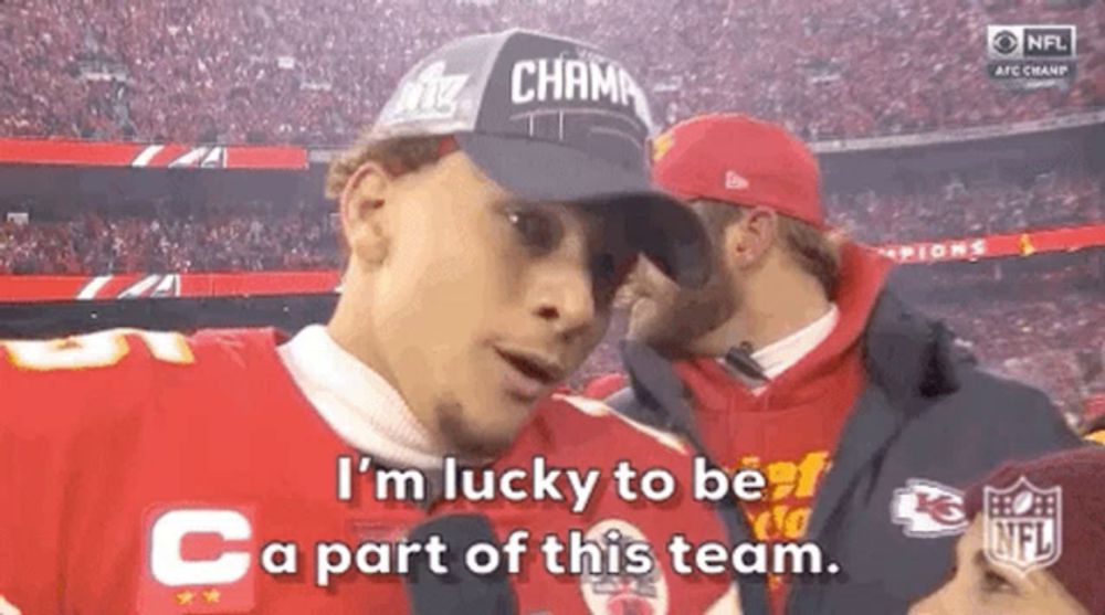 a man wearing a hat is talking into a microphone and saying `` i 'm lucky to be part of this team ''