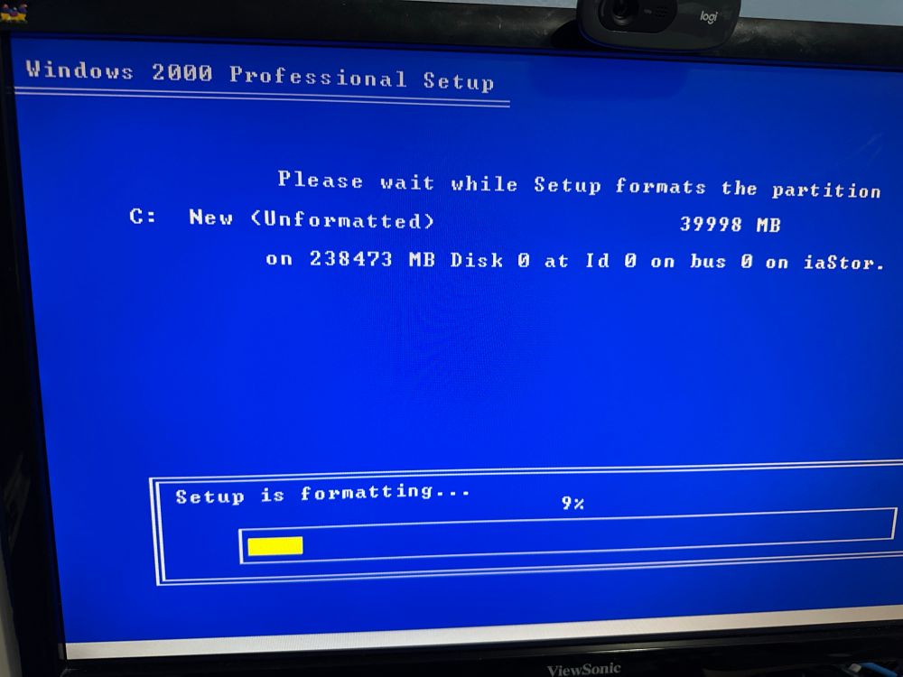 Picture of a computer monitor showing the text-mode portion of Windows 2000 setup. Setup is currently formatting the hard drive.
