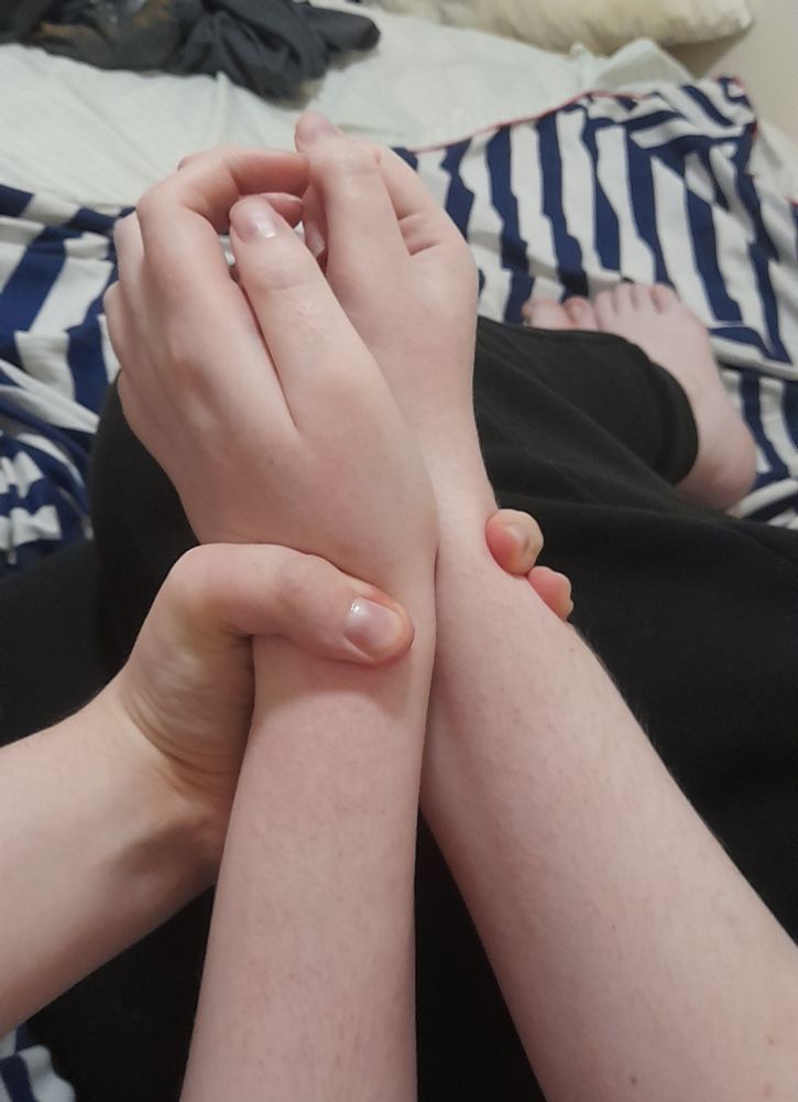 one hand holding two wrists together in place 