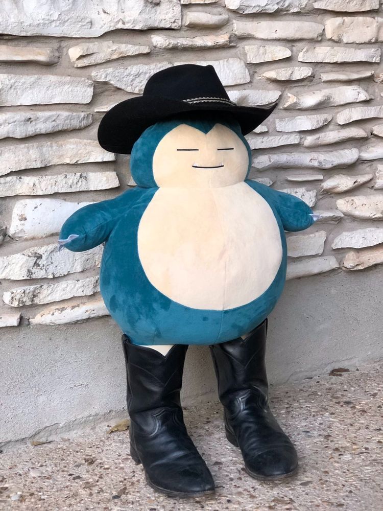 a snorlax doll wearing a cowboy hat. it vaguely resembles dave filoni