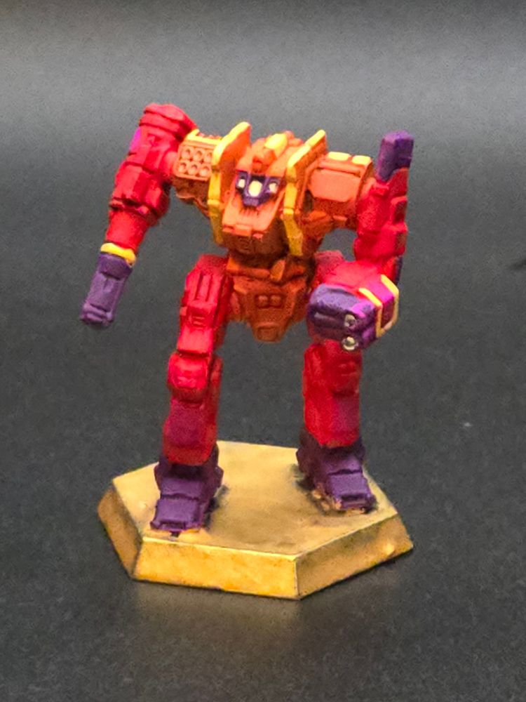 A battletech miniature. It has a paint scheme inspired by sunsets. It has light and dark purple at the ends of the arms and legs, red on most of the limbs, and an orange main body with gold highlights. This Grendel is vaguely humanoid, but the right arm is just a big gun. 
