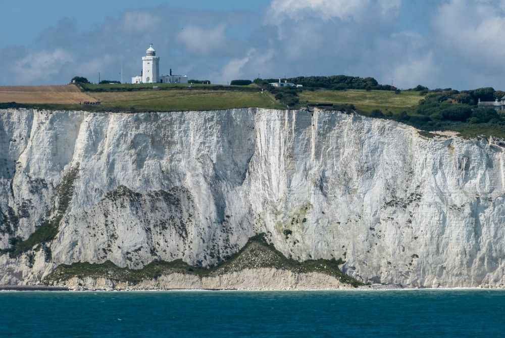 Image of a white cliff (White Cliffs of Dover) with a lighthouse on top. By Archangel12 - https://en.wikipedia.org/wiki/White_Cliffs_of_Dover#/media/File:Dover_cliffs,_South_Foreland_Lighthouse_(7961633780).jpg