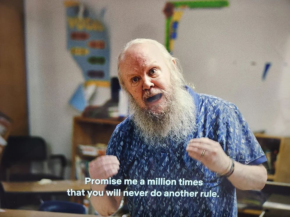 Scene from "I think you should leave" where a man (actor Biff Wiff who also resembles Santa Claus) has confided to his "shirt brother" (Tim Robinson) that he heard a song that made him think there are no rules; and after trashing an elementary school classroom, he asks Tim Robinson's character: Promise me a million times that you will never do another rule.