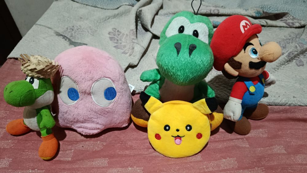 Yoshi with a arraiá hat, the pink ghost from pacman pinky, another bigger yoshi, a Pikachu tiny purse and a Mario plushie.
