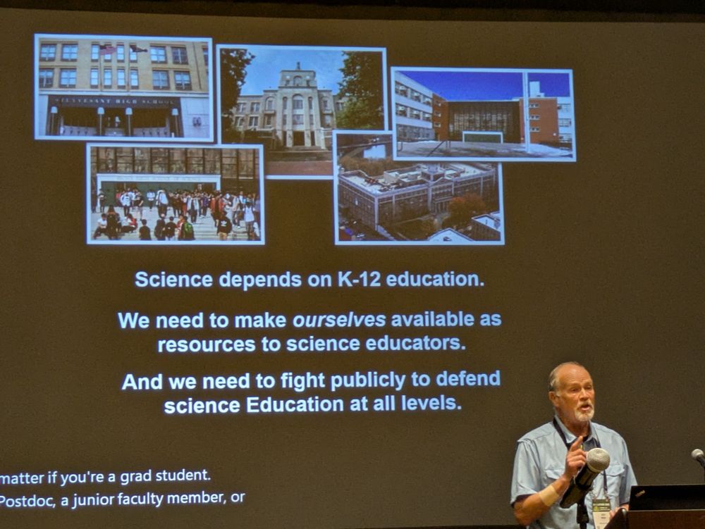 A man at a podium delivering a talk during a conference. The slide behind him reads "Science depends on K-12 education", "we need to make ourselves available as resources to science educators", and "And we need to fight publicity to defend scince education at all levels".