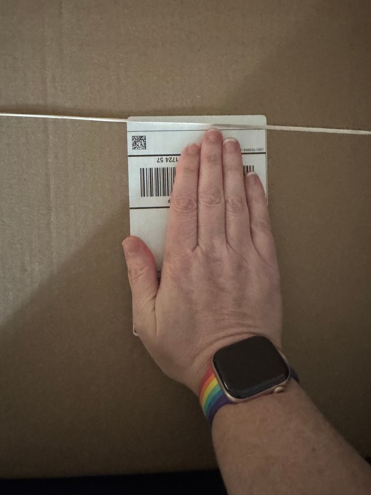 A package with a random rubber band on it, with my hand covering the address label