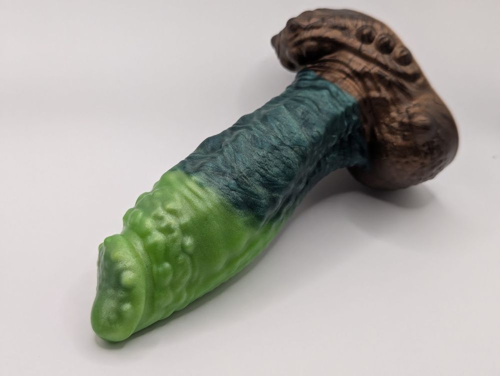 Photo of the Arboris Tree Dragon dildo from Uberrime, showing some greens and a gorgeous bronze base.