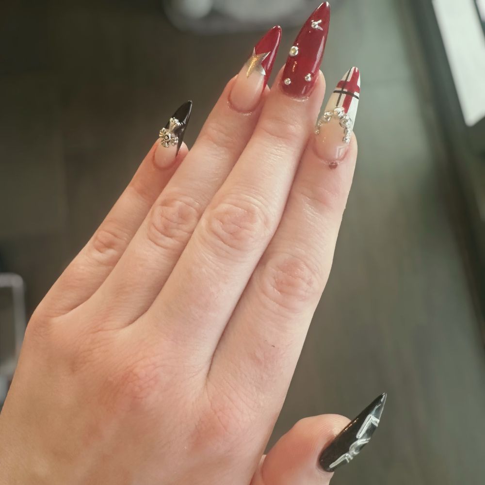 Pink’s nails that are a red, white, and black theme with chrome accents. The nails evoke the anime Nana. 