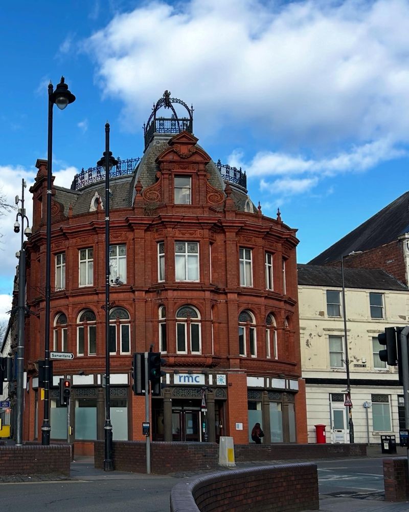 Corner building, 3storey and attic, red clay brick, ironwork crown