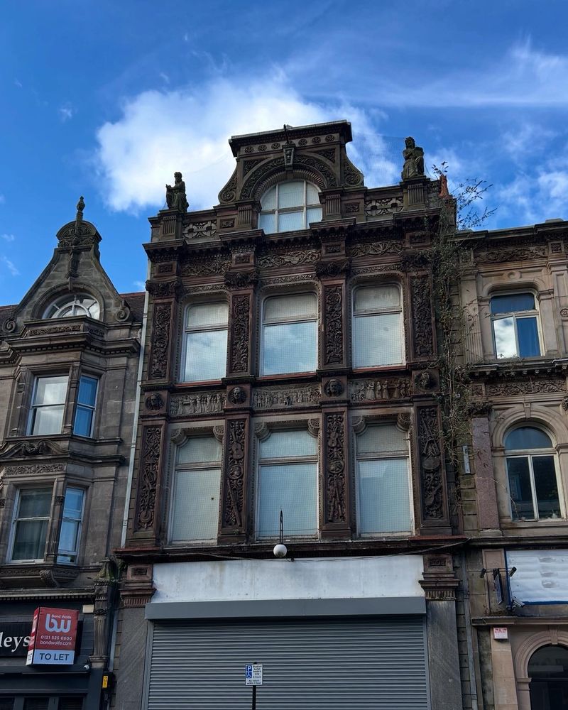Frontage of former music shop, modelling of guitars, violins and other musical instruments in frieze to front elevation 