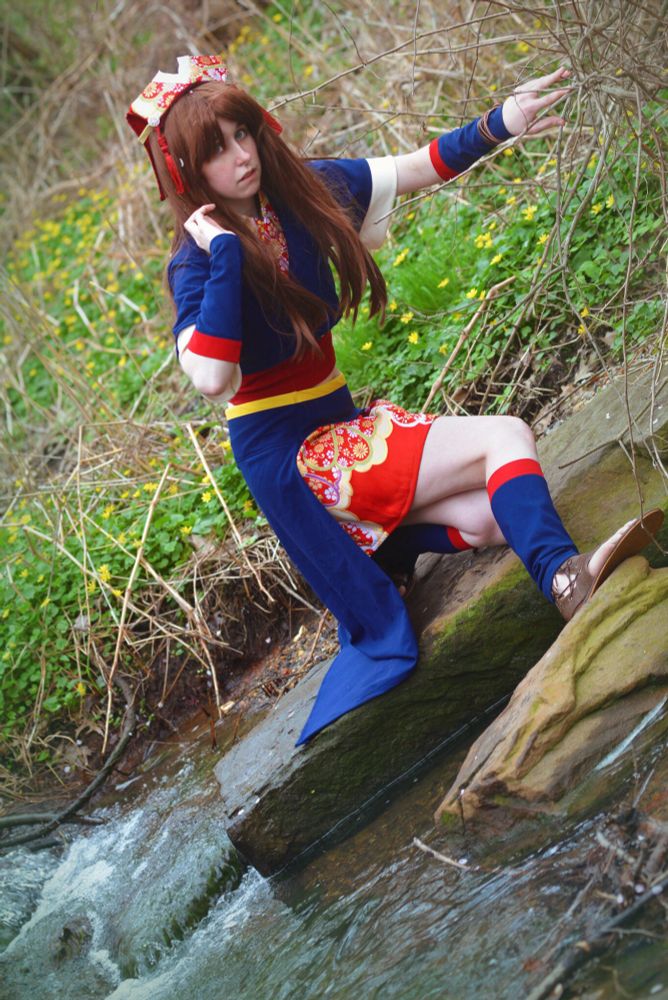 A cosplay of Kirara Mikumari from Samurai 7. The cosplayer is stepping across a brook of water into a stone.