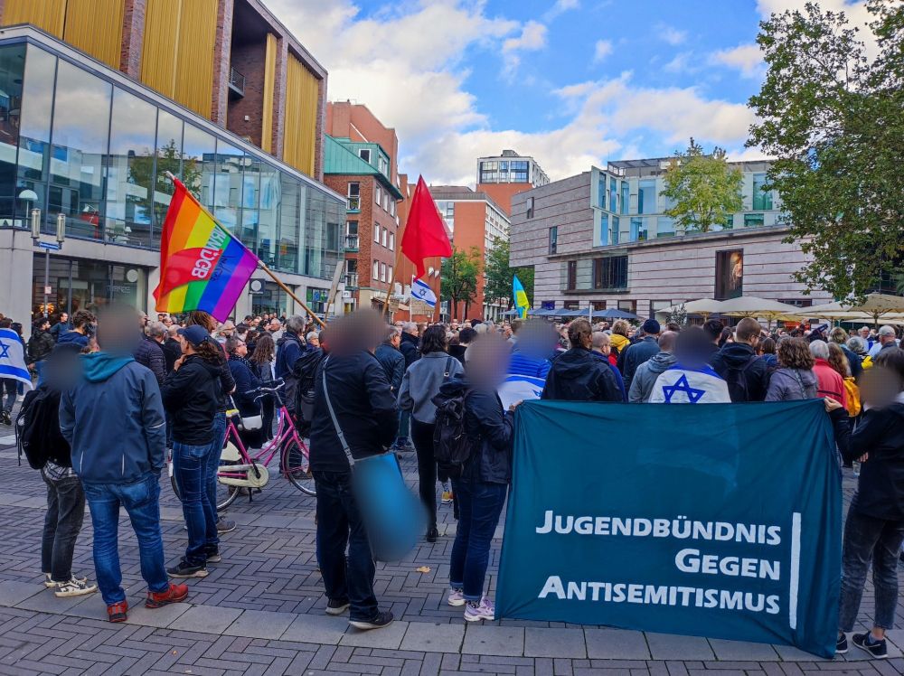 Einige Menschen, die auf der Kundgebung waren. Man sieht unter anderem israelische Flaggen, eine Regenbogenfahne vom DGB u. eine Ukraine-Flagge. Ein großes Banner, auf dem "Jugendbündnis gegen Antisemitismus" steht.