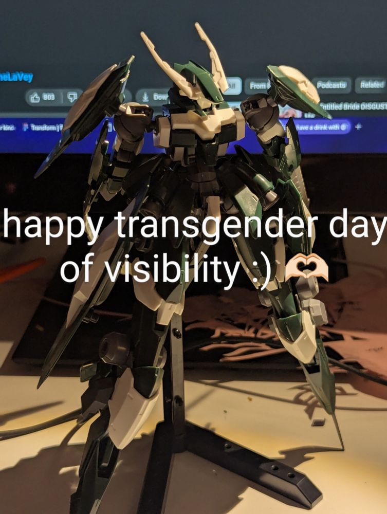 reginglaze julia gundam posed on a stand with the words "happy transgender day of visibility :) 🫶🏻" edited over top
