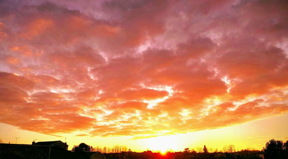 Un superbe coucher de soleil où le ciel paraît en feu avec ses nuages d'un jaune orangé spectaculaire ! 🔥 