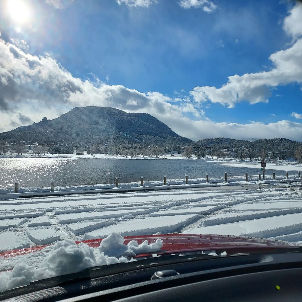 View of Lake Estes, CO with snow-covered Prospect Mountain in background.