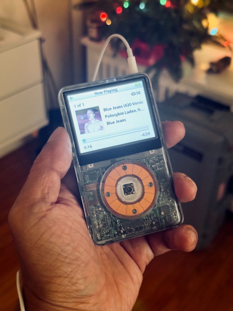 a 5th generation iPod, customized with a translucent front case. It is playing Blue Jeans (420 version) by Psilocybin Laden. 