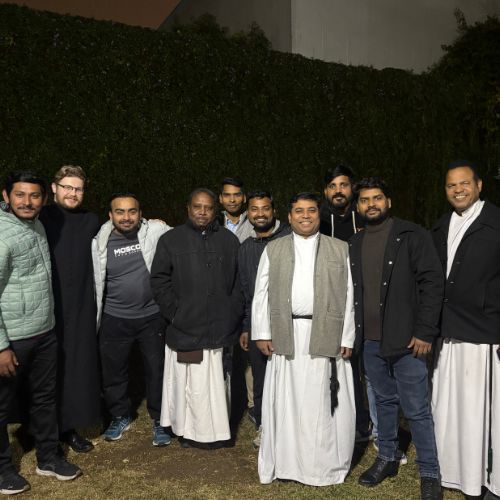 Photo: First year ordinand, Sebastian, with the Brothers and some of the monastery staff at the end of their New Years Carols garden party