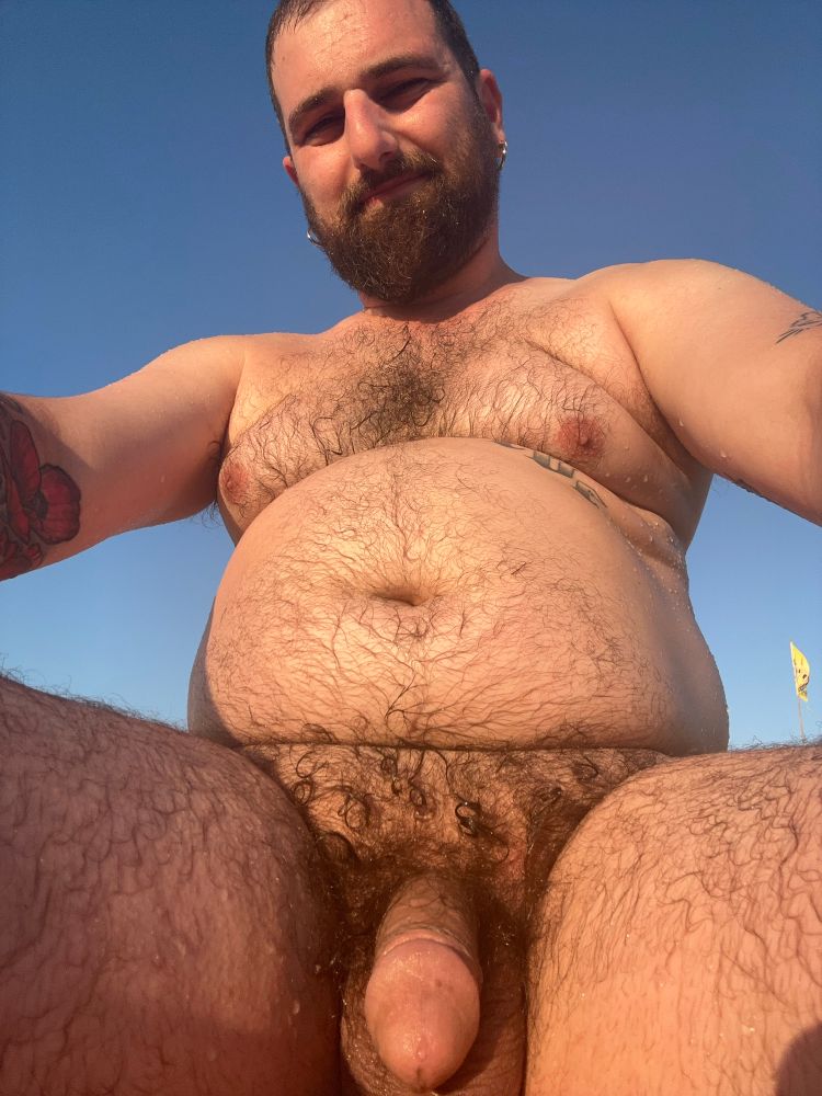 Selfie of me on the nude beach in Tuscany. My pubes are curled from a dip in the Mediterranean Sea and the sun is shining on my belly.