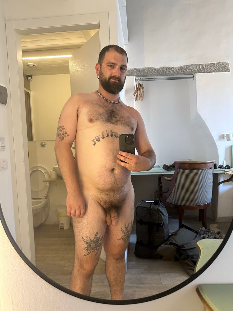 Nude mirror selfie of me in my room in Florence. I’m wearing a chain necklace and earrings and nothing else. My peen is out and my balls are hanging low because of the heat.