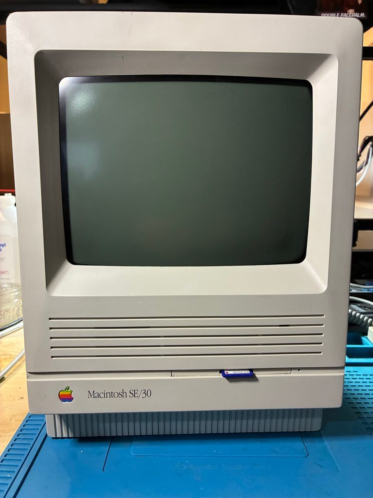 Macintosh SE/30 computer with a BlueSCSI SD slot mounted in the floppy drive opening. 