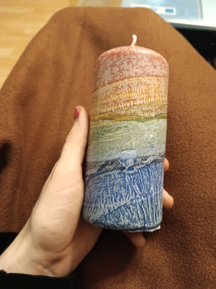 A rainbow coloured candles that I am holding in my hand