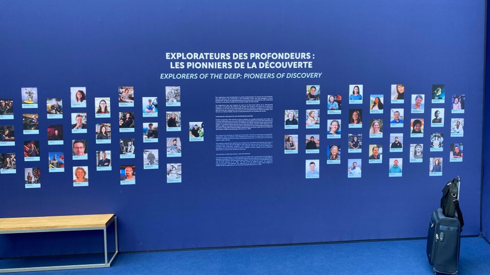 Large blue-coloured “Explorers of the deep” wall with pictures of deep ocean explorers at the #UNOC3 exhibition in “The Whale” in Nice, France