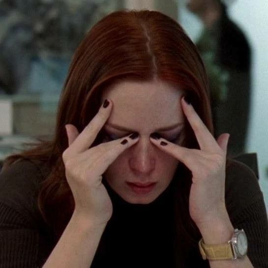 imagem da personagem emily charlton, de o diabo veste prada, com as mãos no rosto e expressão de cansada.