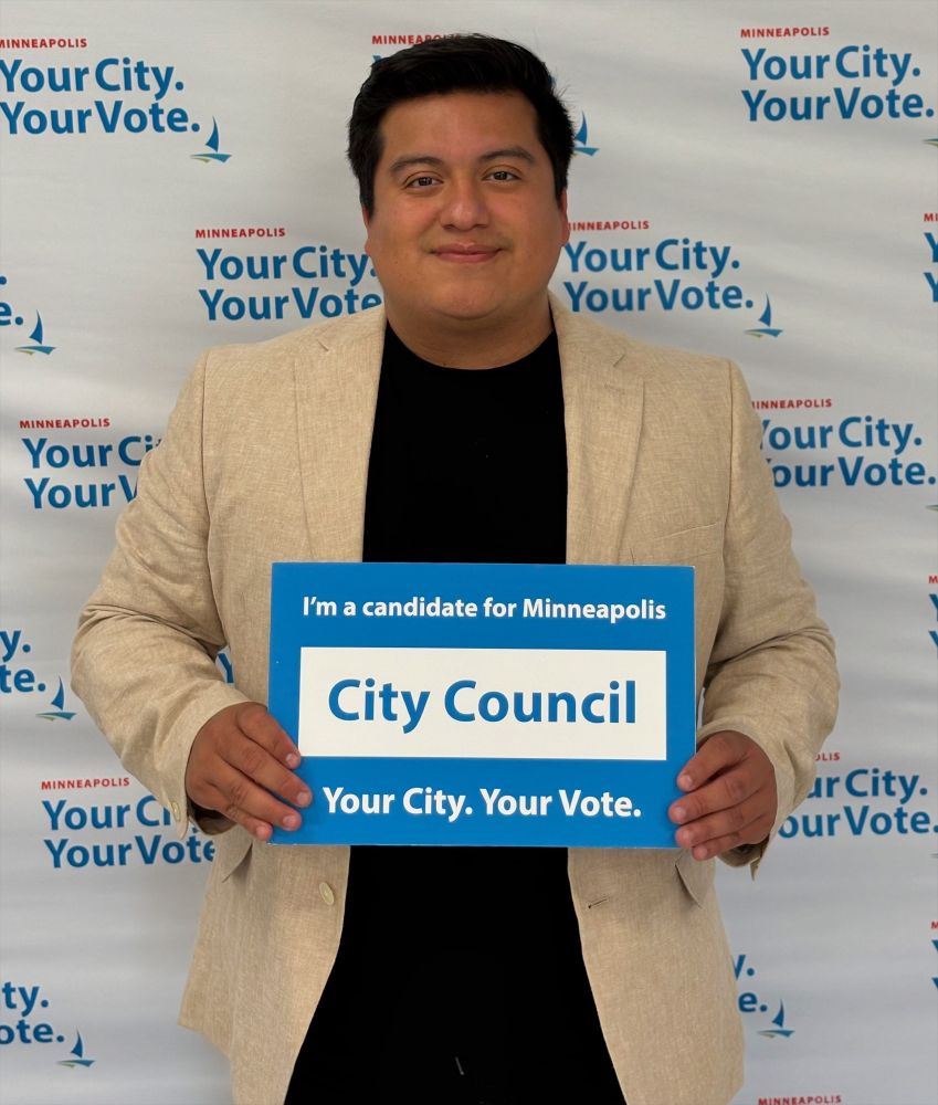 Jason taking a photo after filing for office. 

With a sign that says, “I'm a candidate for Minneapolis
City Council. Your City. Your Vote.”