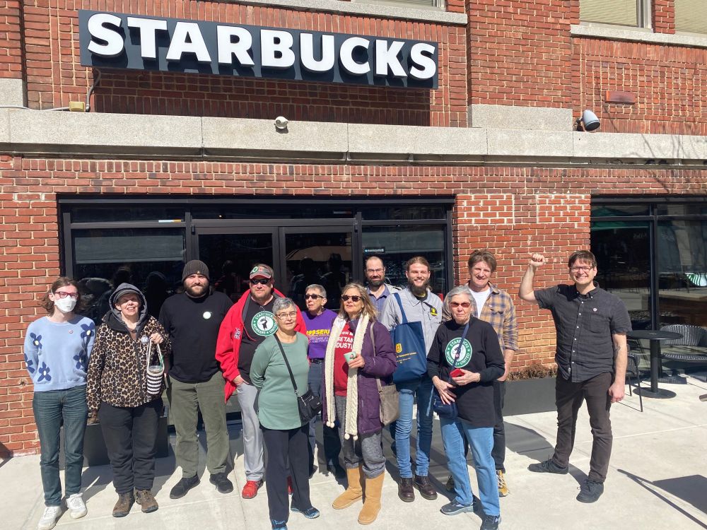 A large group of union supporters stand outside a Starbucks store after their sip-in event
