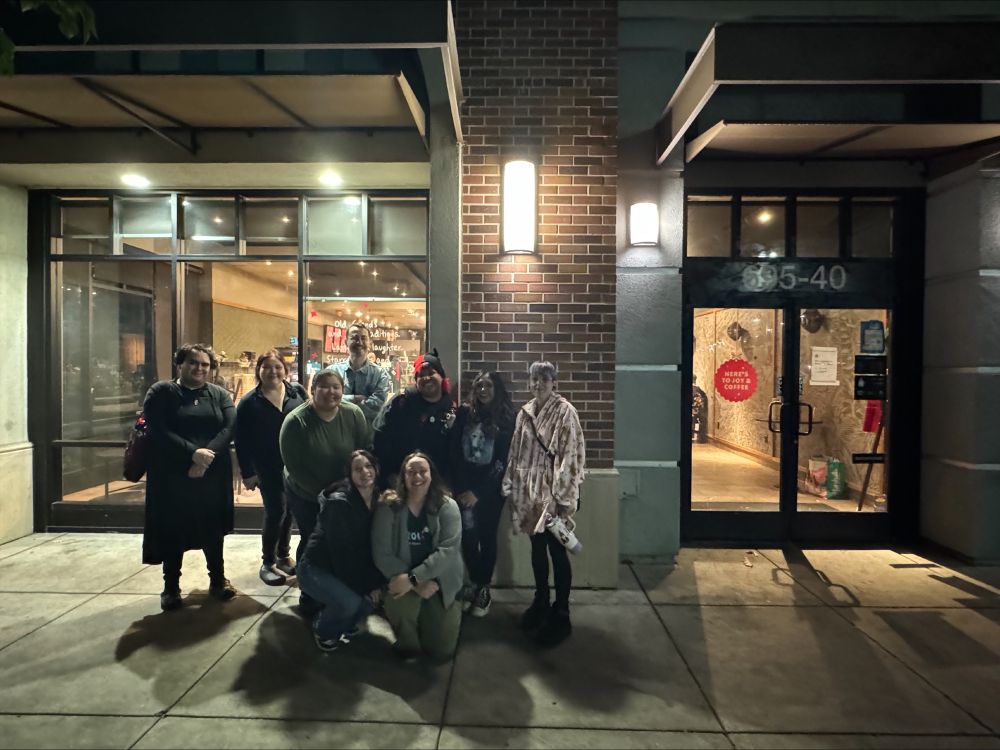 A group of 9 SBWU members and allies support their union victory outside of a Starbucks store