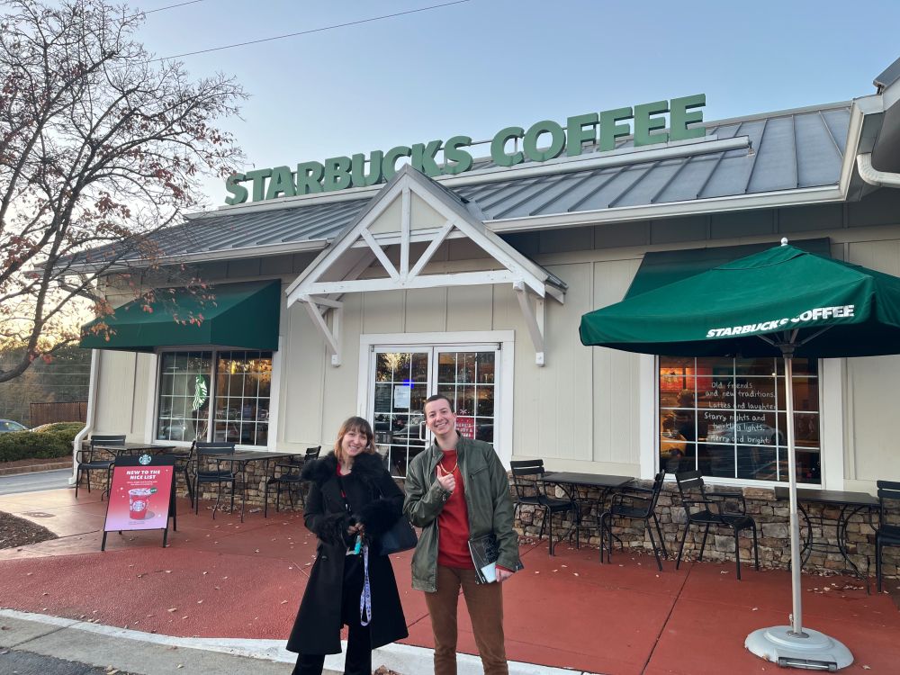 Two SBWU members celebrate in front of their Starbucks store