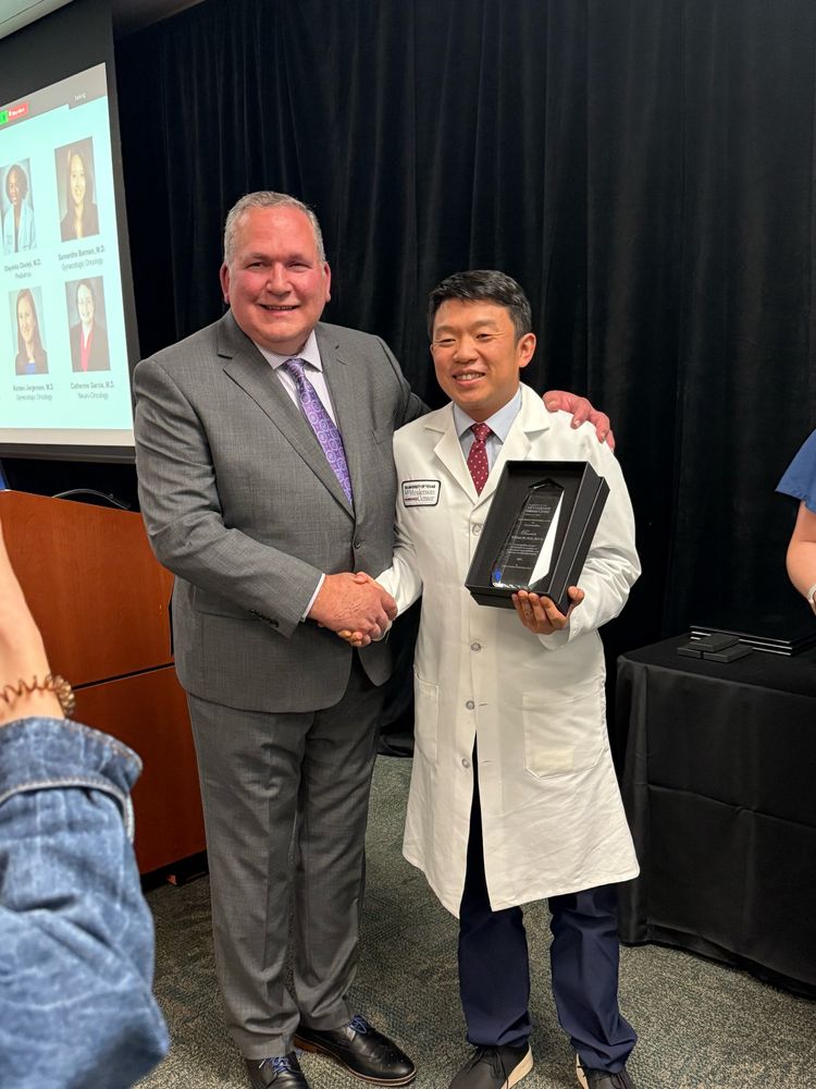 Dr Mi shaking hands with the award giver