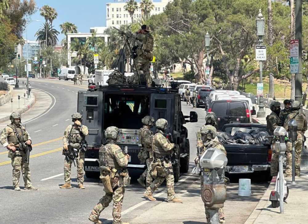ICE agents in full combat gear on the streets of Los Angeles. On top of a military vehicle is an agent with a full-ass machine gun on a tripod. 