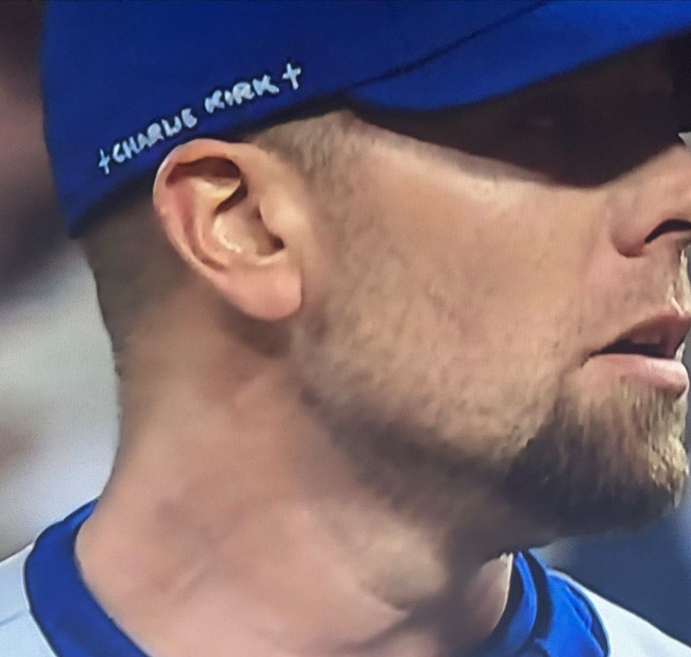 Blake Treinen of the Los Angeles Dodgers closeup, with "Charlie Kirk" and two crosses written on his cap in sharpie. 