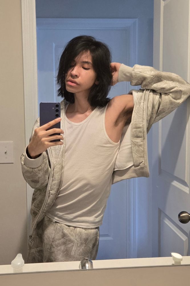 mirror selfie photo of chrissy (that's meee :3) in the bathroom, wearing matching camo zip-up hoodie & sweatpants and a tank top, trying to do a sexy pose that shows off my armpit. i know what you FREAKS are into...