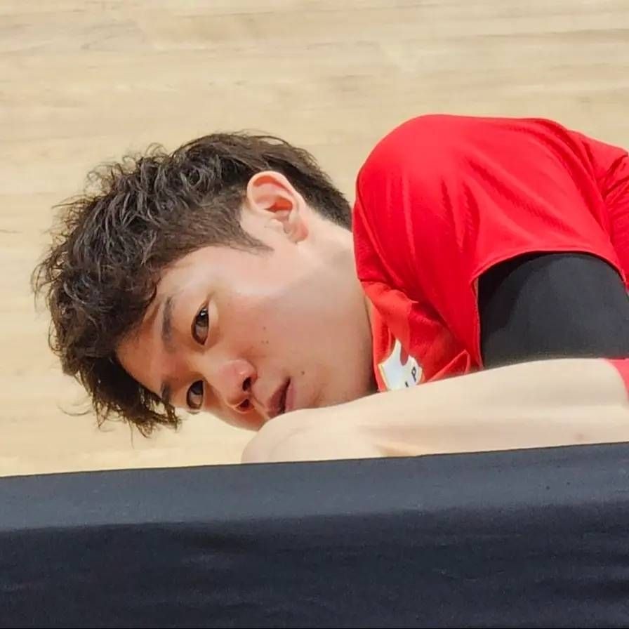 Photo of Yuki Ishikawa from behind the stand where he's exercising on court, giving the camera a seriously intense side eye that looks vaguely murderous.