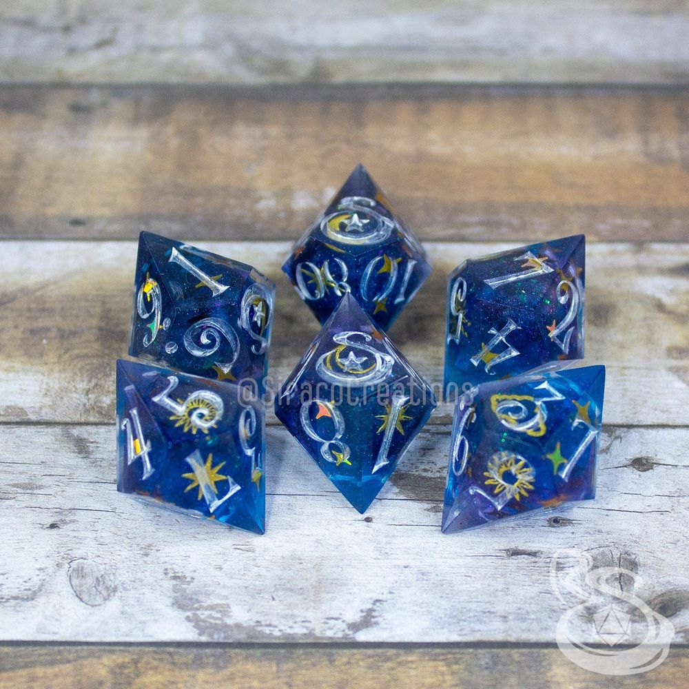 5 d10 + 1 d% pointy shard dice covered in moons and stars stickers, encapsulated in resin. the font used is a whimsical curly font. the high faces have been replaced with a stylized S and a star.