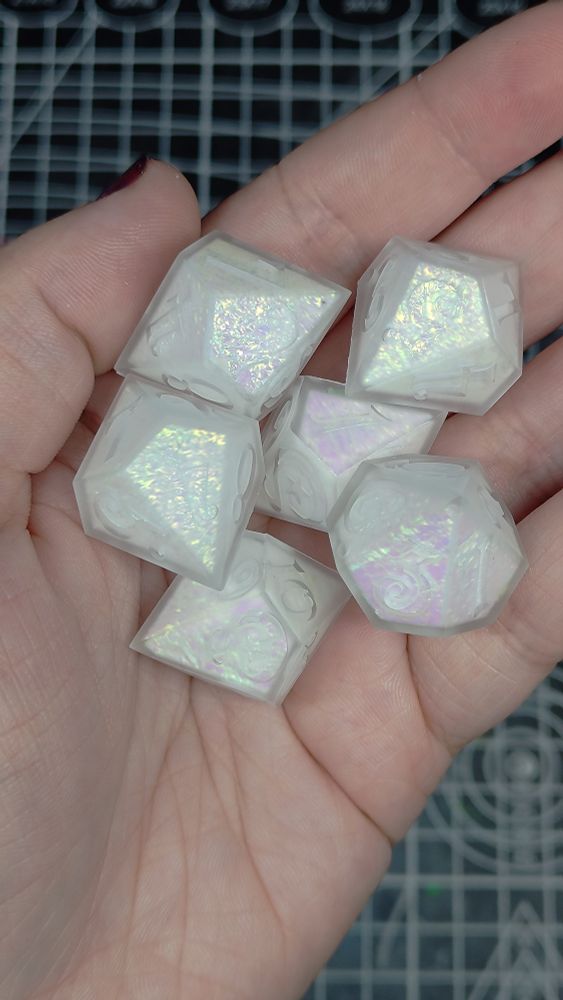 6 d10 dice that are pointed like gems. The dice are matte, and have white centers that have been wrapped in mylar film.