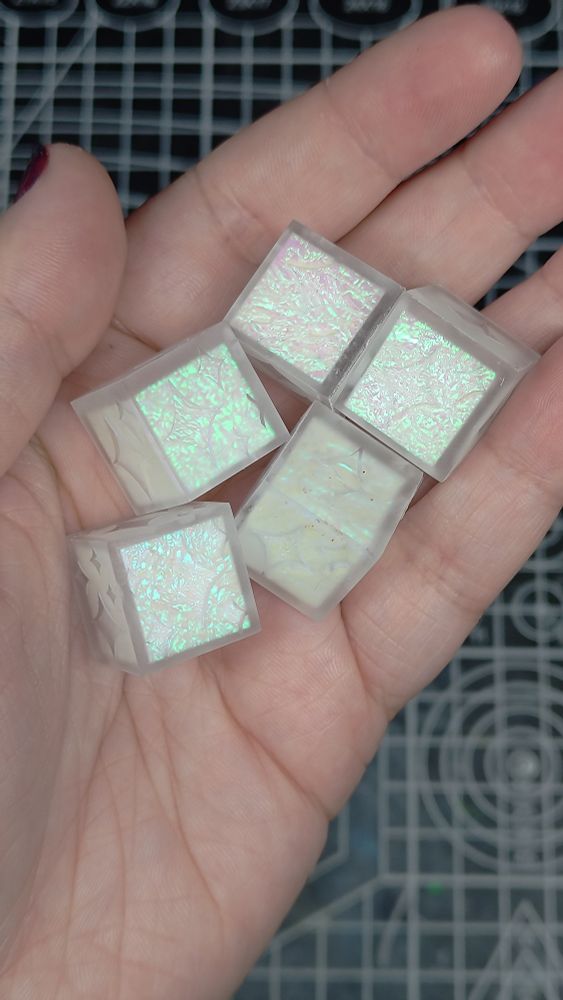 5 d6 dice with sparkles for numbers. The dice are matte, and have white centers that have been wrapped in mylar film.