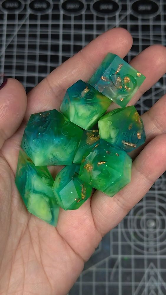 Emerald Ocean Polyhedral set. 8 differently shaped dice that are matte, not shiny. The dice are made of blue and green resin with gold metallic flakes.