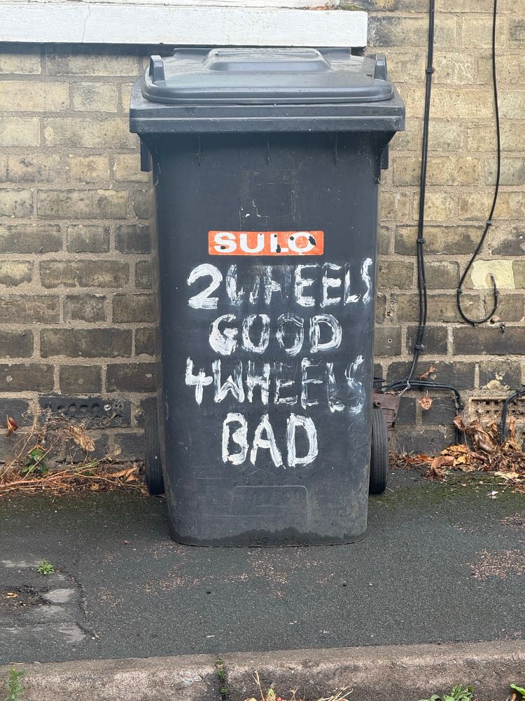 Wheely bin with the words “2 wheels good 4 wheels bad” painted on it.