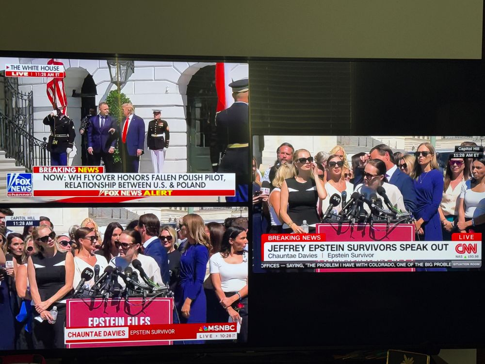 Monitor showing CNN and MSNBC covering a press conference while Fox News covers a flyover. 