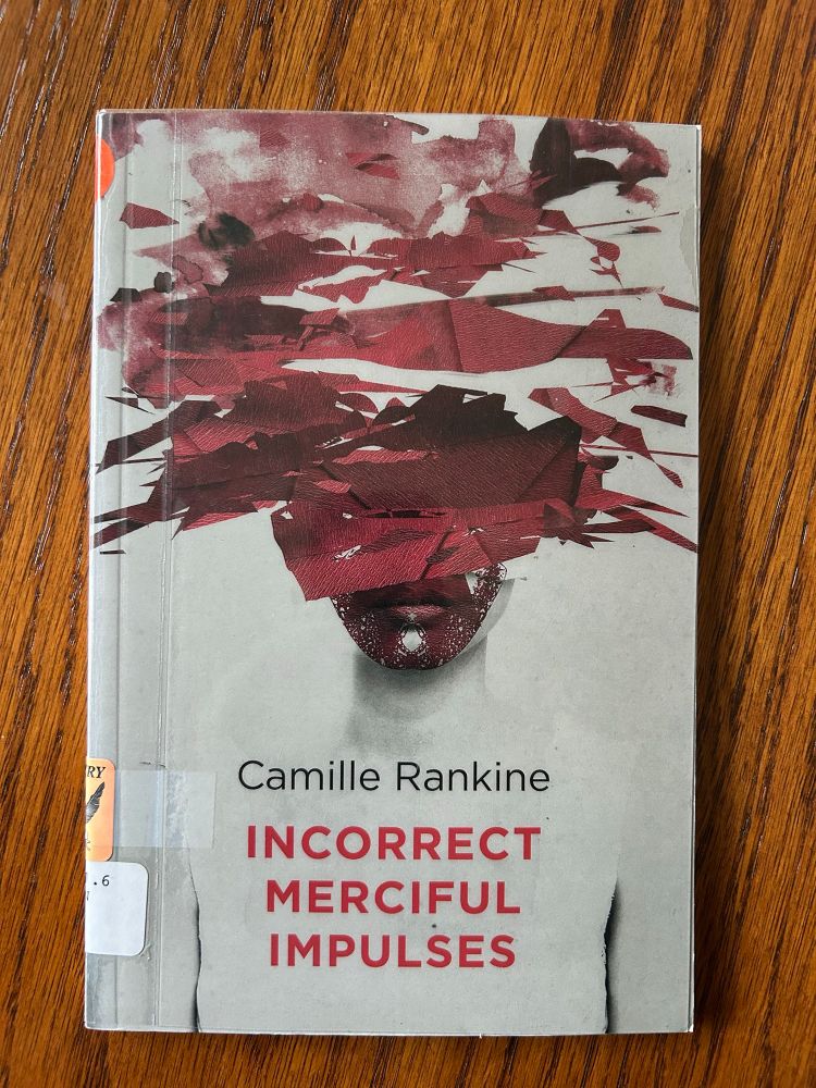 Photo of the cover of Camille Rankine’s 2016 poetry collection
“Incorrect Merciful Impulses” 

Cover design features a figure in monotone whose face is partially obscured by collage-like elements of almost lace-like quality about the lips and chin and then almost like shredded paper blending into smudges in a deep red-plum cover extending up over the head and to the top edge of the cover. 