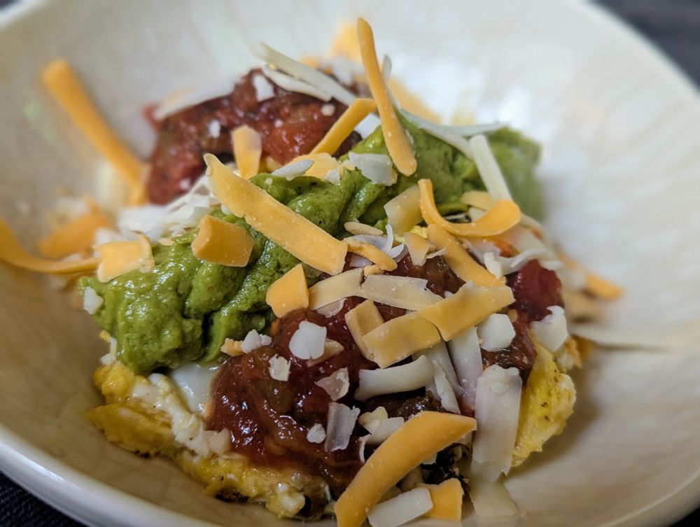 Eggs scrambled with chopped bacon, topped with mashed avocado, hot salsa, and shredded Mexican cheese blend. Photo by @JonHutson August 3, 2025