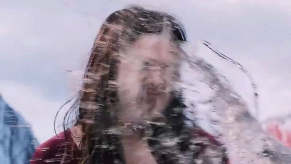 a man with long hair and a beard is standing in a pool of water .