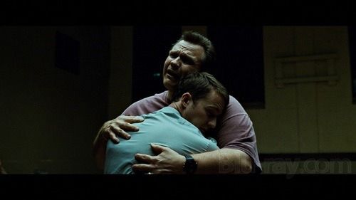 A still from the movie Fight Club. In a dark room, Meatloaf (the musician and actor) embraces Edward Norton.