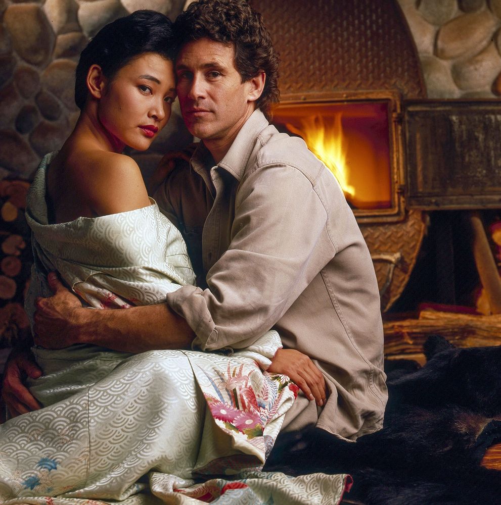 Joan Chen and Michael Ontkean by a fireplace