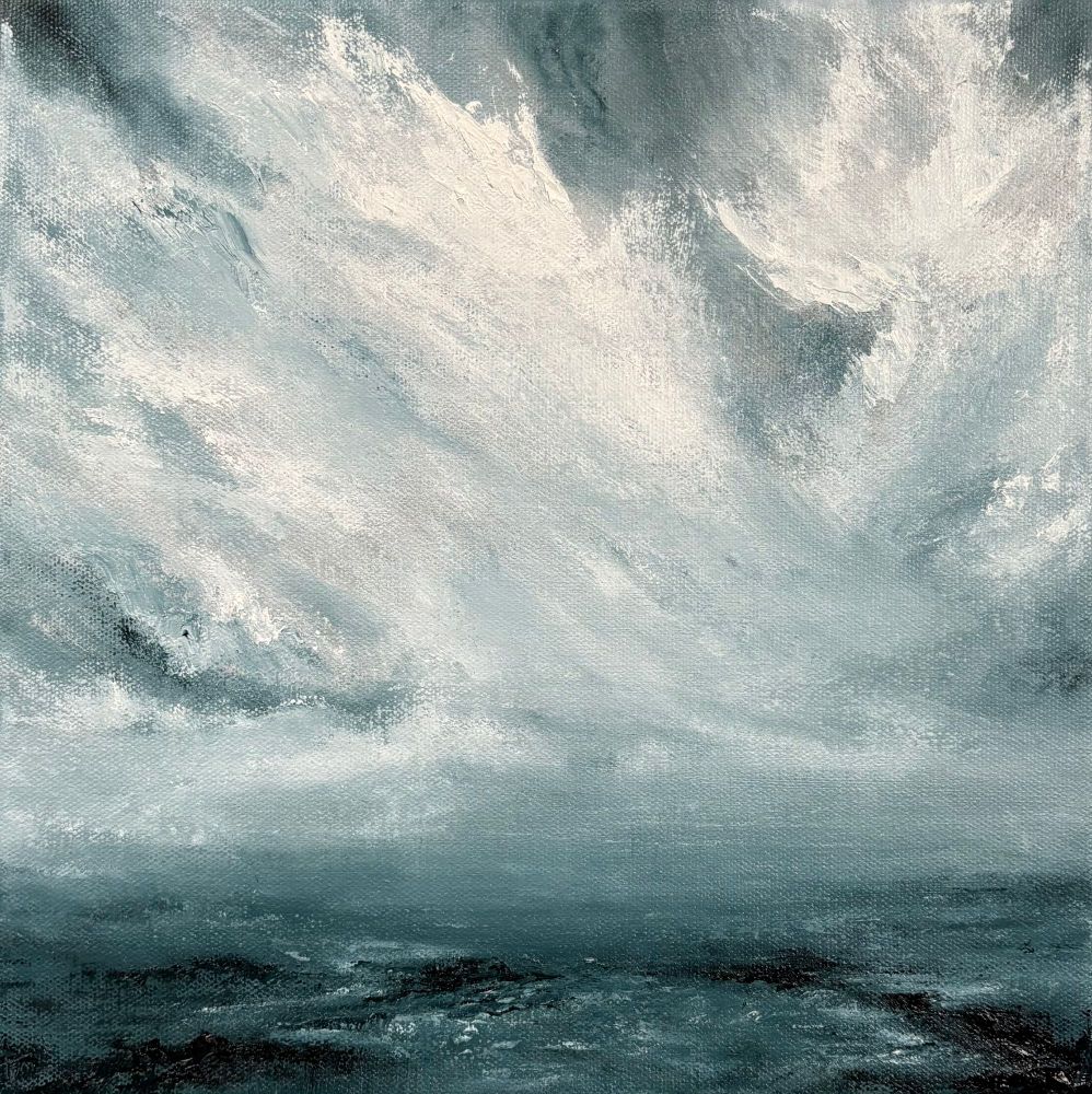 Original seascape oil painting by Tisha Mark, "In the Storm I" 12"x12" oil on canvas (2024). An atmospheric, moody seascape painting interpreting a winter storm. There are large white cloud formations over a dark blue sea with a rocky coast. Painted in a limited palette of blues and whites.